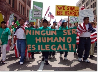 Members of the South Central Farm attending the immigrant rights march for amnesty in downtown Los Angeles California on May Day, 2006. The banner, in Spanish, reads "No human being is illegal".