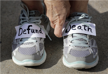 A protester adjusts signs she placed on her shoes at an anti-abortion rally in Austin, Texas, on Tuesday. AP