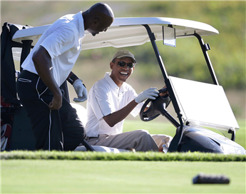 President Obama shares a laugh with former NBA basketball player Alonzo Mourning at Vineyard Golf Club in Edgartown, Mass., on the island of Martha's...